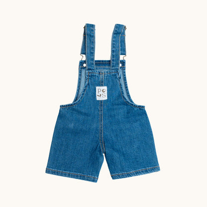 EVERYDAY DENIM OVERALLS; 100% Organic Cotton; Medium-weight denim fabric; Press snaps at the crotch for easy dressing (Size 0 & Size 1); Adjustable straps and front patch pockets; Logo badge at the back.