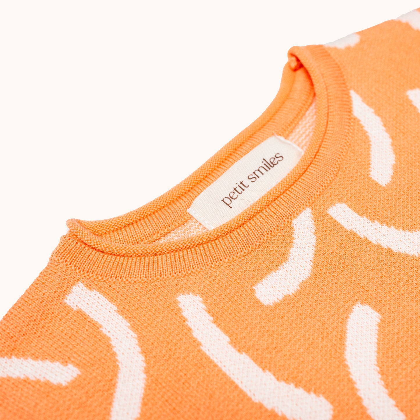 KNITTED BRUSH ORGANIC TEE – CORAL/CREAM; 100% Organic Cotton; Made from GOTS-certified organic cotton; 'BRUSH' Jacquard pattern; Rolled edge at the neckband; Rib finish at hem and cuffs; Dropped shoulder; Relaxed fit