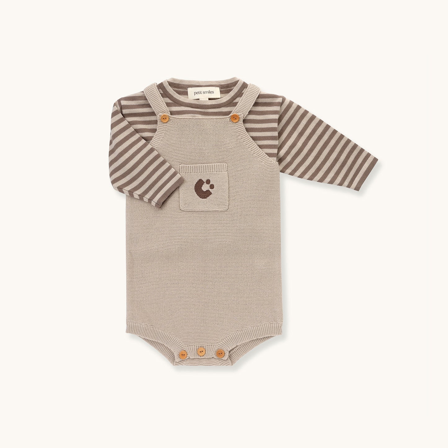 KNITTED SINGLESUIT - BEIGE; 100% Organic Cotton; Jacquard singletsuit made from GOTS-certified organic cotton; Features convenient press snaps at the crotch for effortless dressing; Rib finish and neck, armholes and leg opening.